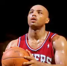 A close-up of Charles Barkley's face; he is smiling broadly and is wearing a white shirt.