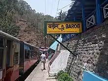 Narrow platform and train, with a bilingual sign