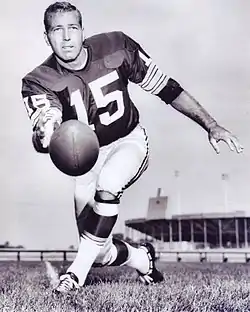 Starr in uniform tossing a football underhanded