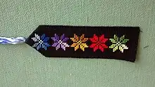 Bookmark of black fabric with multicolored Bedouin embroidery and tassel of embroidery floss