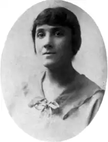 A young white woman's portrait in an oval frame. Her hair is dressed close to her head and off her neck and shoulders; she is wearing a simple blouse with a wide flat collar and a ribbon tie.