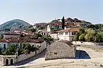 White houses with greyish roofs on a hillside.