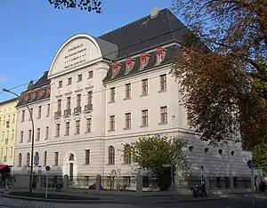 Photograph of a four-story building with a tile roof