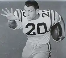 A football player wearing light colored uniform with the number 20 on it.