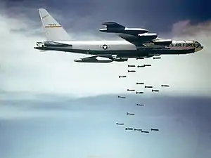 A large aircraft dropping bombs mid-flight.