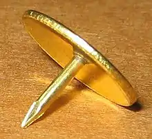 A brass tack with point downward