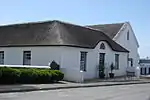 This is the Bredasdorp Museum Complex which is already proclaimed a national monument.
The Rectory and the former Anglican Church, now a hall, date from the earliest years of the town.
The Rectory is a very fine Old Cape thatched house.
Now the complex forms the Bredasdorp Museum.
The former house of the Rector of the Anglican Church in Bredasdorp.
Type of site: House
Previous use: Residence : Parsonage.
Current use: Museum.