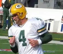 Favre in uniform jogging on a football field