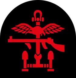 Insignia of Combined Operations units it is a combination of a red Thompson submachine gun, a pair of wings and an anchor on a black backing