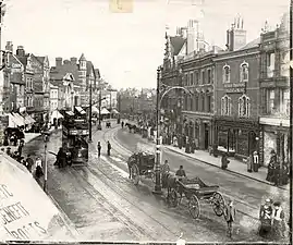 Broad Street, Reading, looking eastwards from an upper storey window, c. 1904. A tramcar heads eastwards, and two horse-drawn cabs wait in the middle of the road, by the trolley-pole.