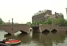 The Waalseiland bridge (bridge no. 283), designed by Joan van der Mey, in the Amsterdam School style, with the Scheepvaarthuis in the background.