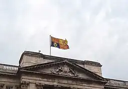 The Royal Standard of the United Kingdom used outside of Scotland, featuring the Royal Banner of Scotland in the second quarter, flying over Buckingham Palace, London.