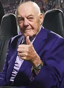 Bud Grant wearing a purple suit and giving a thumbs-up.