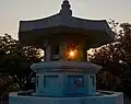 sunset through a fountain on the premises of the temple