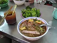 A bowl of bún ốc at a street food stall