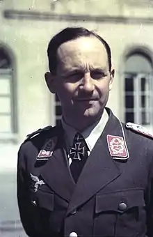 A man wearing a military uniform with an Iron Cross displayed at the front of his uniform collar.