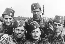 A group photograph of five soldiers wearing SS uniforms and fez headgear