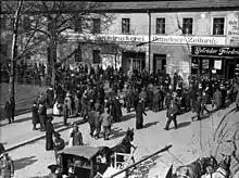 A large number of people crowd outside a building.