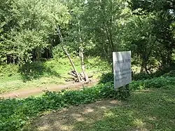 River crossing with vegetation on both banks and a white sign identifying it as Byram's Ford