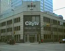 A view of a building at a street corner with Citytv signage.