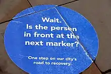 A circular blue sign stating "Wait"