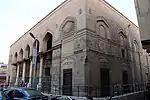 Exterior of the mosque, seen from the west, with the entrance portico on the left. One of the mosque's chamfered corners is visible in the middle.