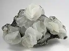 Rhombohedrons of calcite that appear almost as books of petals, piled up 3-dimensionally on the matrix