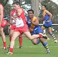 Canadian Aussie Rules player kicks ball downfield against Nauru in the 2008 International Cup.