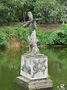 Statue of Cao Lỗ holding the magical crossbow he built for An Dương Vương