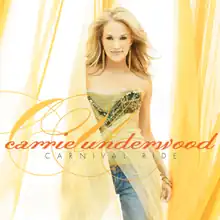 The cover features Carrie Underwood wearing a green top and blue jeans, surrounded by yellow curtains. The artist's name is written in orange cursive lettering and the album title is below it in black lettering.