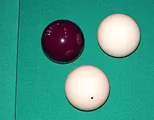 Image 14A set of standard carom billiard balls, comprising a red object ball, one plain white cue ball, and one dotted white cue ball (replaced in modern three-cushion billiards by a yellow ball) for the opponent (from Carom billiards)