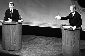 A monochrome picture of Carter and Ford, both standing at podiums during a debate.