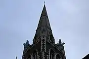 The building is described as "particularly idiosyncratic" by Cherry and Pevsner. Bronze lion and bull at the base of the spire