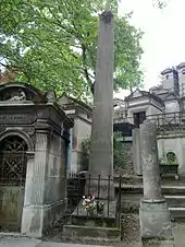 Obelisk of stone on a small tomb. The obelisk is inscribed with the name Champollion.