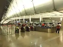 The concourse area at the platform level. A set of faregates separate the paid and unpaid areas.