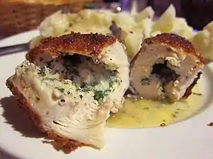 Pieces of chicken Kiev in butter sauce spread on a plate