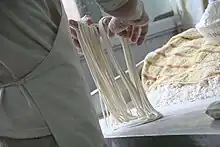 Pulling wheat dough into one thin strand to form lamian