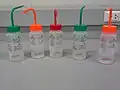 The back of wash bottles with labels for indicating types of substances inside.