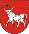 A coat of arms depicting a white bull with an angry expression and a golden cross protruding from its head all on a red background