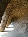 Colonnaded pathway where the road projects out from the hillside, with the vaulting forming a retaining wall which curves over to support the road, and transmits the load onto sloping columns.