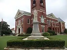 A picture of the confederate monument standing in front of the courthouse