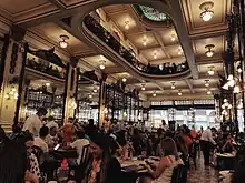 Overview of an indoors restaurant with numerous people sitting at the tables