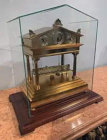 Bronze motion clock in glass case