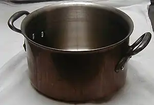 A copper saucepot (stainless lined, with cast iron handles)