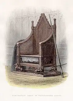 High-backed gothic chair with the Stone of Scone placed into a cavity under the seat and a sword and shield resting on each arm at Westminster Abbey.