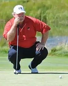 Stadler crouching on a golf course