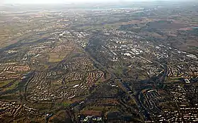 Cumbernauld from the air with St. Maurice's Pond at the bottom and Longannet Power Station on the far side of the Forth at the top. To the left the Forth and Clyde Canal and to the right Fannyside Lochs can be seen.