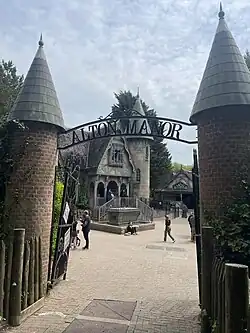 An entrance sign which states "Alton Manor". In the background is an old Victorian Manor House which is the facade to The Curse at Alton Manor