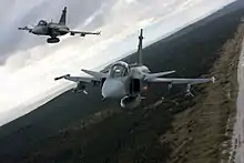  Three-quarter bottom view of two jet aircraft inn flight against a blue sky