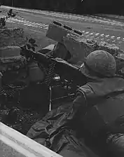 A Marine heavy machine gunner monitors a position along the international neutral corridor in Santo Domingo, 1965.